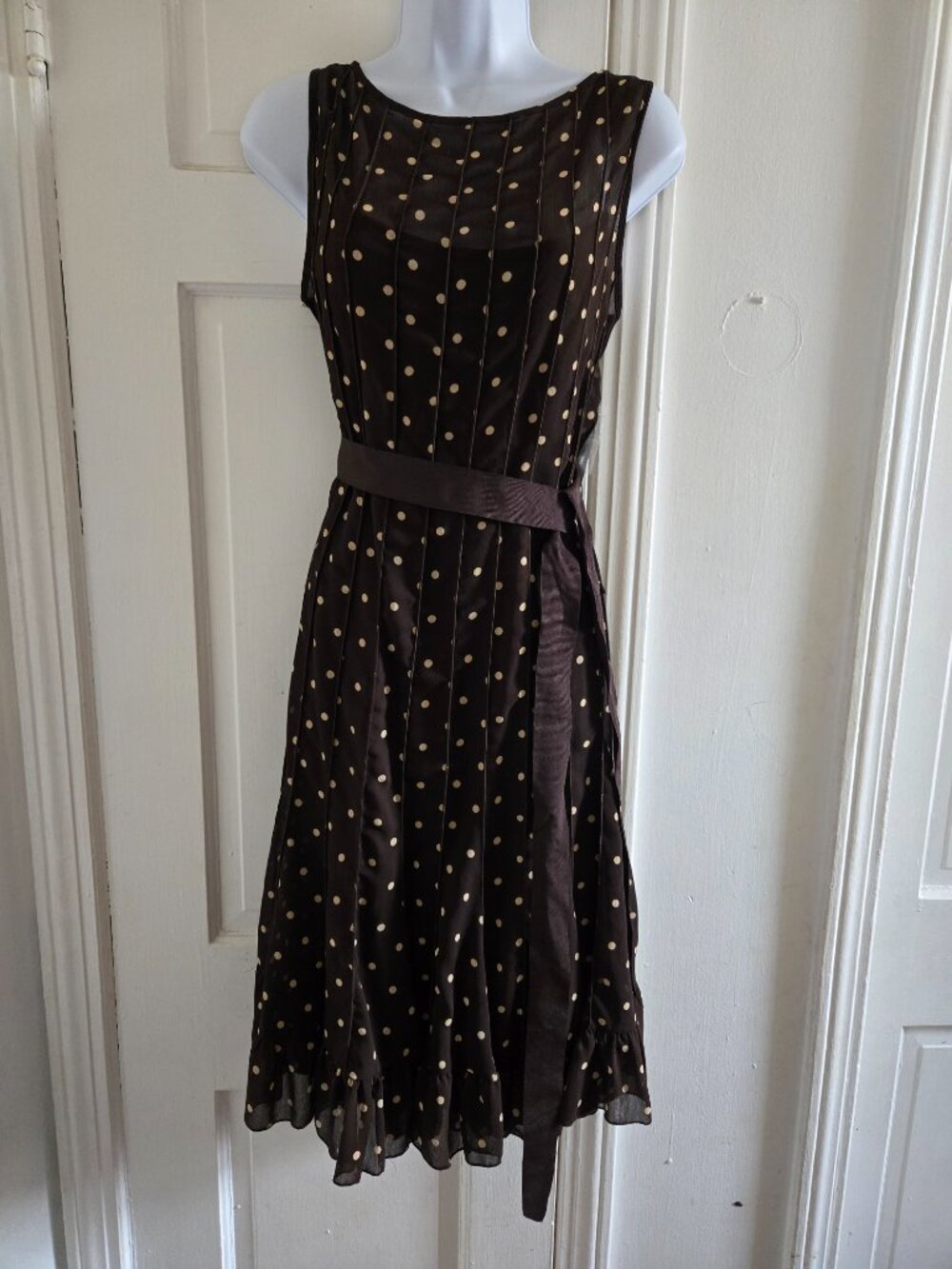 Brown sleeveless polka dot dress with a sheer overlay,